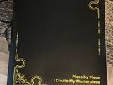 a black book sitting on top of a wooden floor next to a table