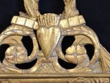 a mirror with a gold frame with a picture on it