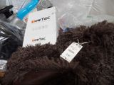 a brown teddy bear sitting on top of a pile of other items