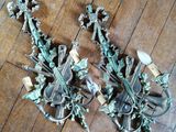 une paire d'appliques murales anciennes posées sur un parquet dans une pièce