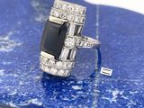 une image représentant une bague en diamant noir et blanc posée sur une pierre bleue
