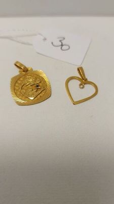 un gros plan sur une paire de boucles d'oreilles en or en forme de cœur