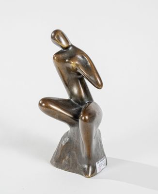une statue en bronze d'un homme assis sur un rocher