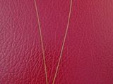 a gold plated necklace with a small elephant on a chain