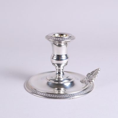 un bougeoir en argent orné d'un oiseau