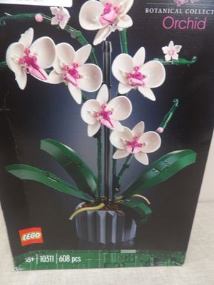 une boîte de Lego sur laquelle figure l'image d'une orchidée blanche