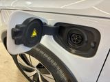 an electric car plugged in to a charging station with a yellow warning sign