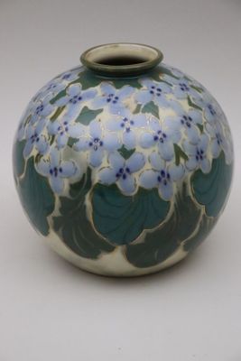 un vase bleu et blanc orné de fleurs bleues