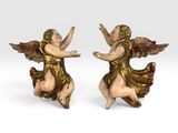 une paire de figurines d'anges posées sur une surface blanche, avec un fond blanc