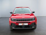 the front end of a red jeep compass parked in a room