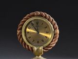 une horloge à l'ancienne, avec une corde autour du cadran, posée sur un socle