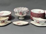 Plusieurs assiettes et tasses en porcelaine sont disposées sur une surface grise