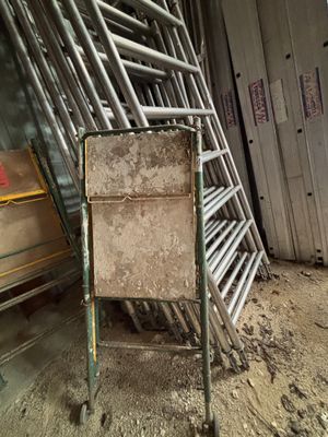 un tas de chaises et une chaise au milieu d'une pièce