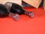 two bottles of wine sitting on a red cloth