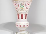 un vase blanc orné d'un motif rouge et or