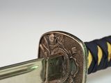 a close up of a sword with a coin on it ' s blade