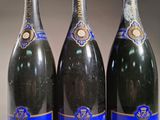 trois bouteilles de champagne posées côte à côte sur une table
