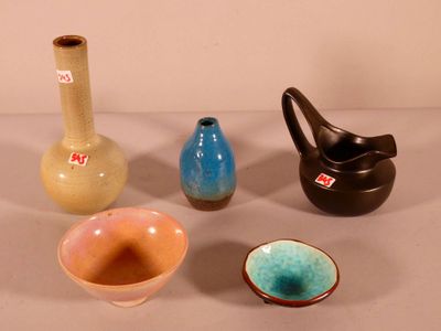 four different colored vases sitting on a table