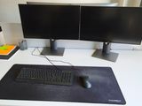 a computer desk with two monitors and a keyboard