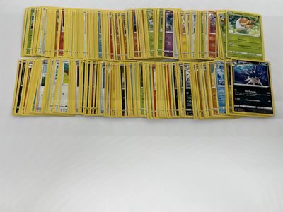 a pile of pokemon cards sitting on top of a white table