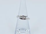 une image d'une bague en diamant posée sur un verre transparent