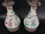 two vases sitting on a table with a black background