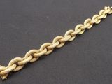 a close up of a gold bracelet on a black surface