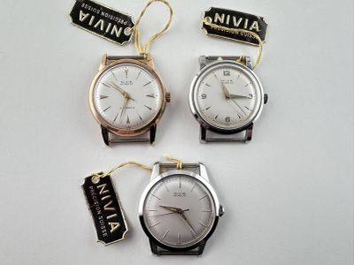 trois montres munies d'une étiquette, posées sur une surface blanche