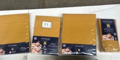 trois sacs de papier doré posés sur une table blanche