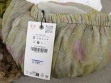 a bag with a price tag on it sitting on a bed