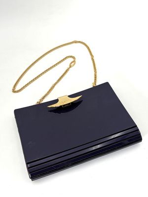 une pochette noire ornée d'une chaîne dorée sur le dessus