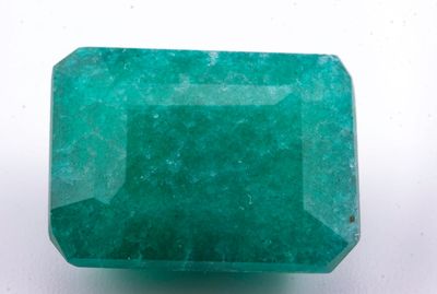 gros plan d'une pierre d'émeraude verte sur une surface blanche