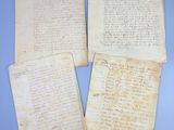 trois vieux papiers portant des inscriptions manuscrites, posés sur une surface bleue