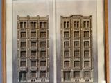 two framed architectural drawings of a building and a clock on a wall