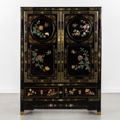une armoire noire ornée de fleurs et d'oiseaux peints