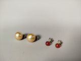trois paires de boucles d'oreilles à clous en perles et corail sur un fond blanc