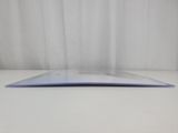 a close up of a laptop on a white surface with a curtain behind it