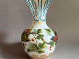 a small vase with a bird on it sitting on a table