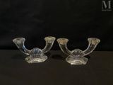 two clear glass candlesticks on a black background