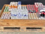a wooden crate filled with bottles of water and soda