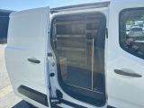 a white van with its door open and a man taking a picture