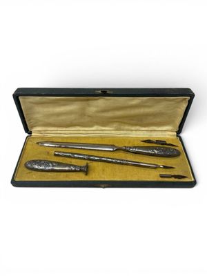 a set of three silverware items in a case on a white background