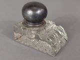 un flacon de parfum en verre orné d'une boule noire
