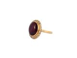 a close up of a gold ring with a red stone