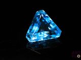 gros plan d'un diamant bleu sur une surface noire