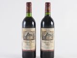 two bottles of wine sitting next to each other on a white surface