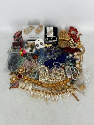 une pile de bijoux assortis sur une surface blanche