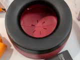a black bowl with a red lid sitting on a table