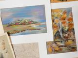 de nombreux tableaux de différentes couleurs et tailles posés sur la table