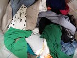 a pile of clothes that is sitting on a bed